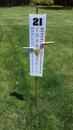 a sign that is in the grass with numbers on it and arrows pointing to different locations