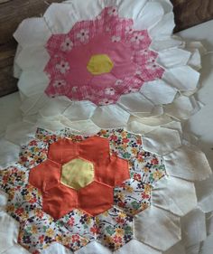 two paper flowers are sitting on top of each other, one is pink and the other is yellow