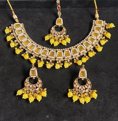 Make a statement with this exquisite jewellery set from Harkirt trade. The beautifully crafted round neck necklace set features stunning stone work in a gold colour. Made in India, this piece is a true reflection of fine craftsmanship and attention to detail. Perfect for any occasion, this jewellery set will elevate any outfit and add a touch of glamour to your look. Ideal for those who appreciate quality and sophistication, this necklace set is a must-have addition to any jewellery collection. Elegant Yellow Meenakari Jewelry, Traditional Jewelry With Stones For Festivals, Festive Chandbali Jewelry With Stone Setting, Traditional Stone Jewelry For Festivals, Temple Jewelry Chandbali With Stone Setting, Chandbali Jewelry With Stone Setting As Gift, Chandbali Jewelry With Stone Setting For Gift, Chandbali Stone Setting Jewelry Gift, Yellow Round Meenakari Jewelry