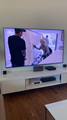 a flat screen tv sitting on top of a white entertainment center