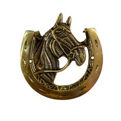 a horse head mounted on the side of a brass plated metal hook with an ornate design