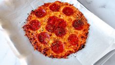 a pepperoni pizza sitting on top of a white napkin