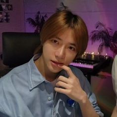 a young man sitting in front of a computer desk with headphones on his ears