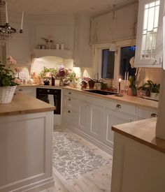 a kitchen filled with lots of white cabinets and counter top space next to a window