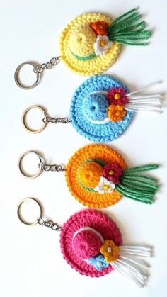 four crocheted keychains with tassels on them