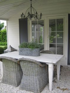 a table and chairs sitting on top of a gravel covered patio