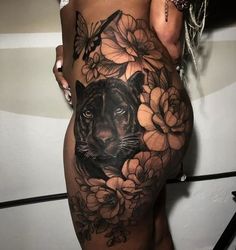 a woman's stomach with a tiger and flowers tattoo on the bottom half of her body