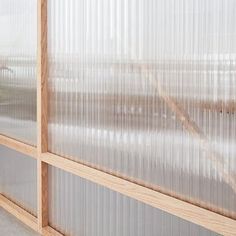 a woman standing in front of a window with sheer curtains on the windowsills