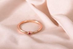 Discover timeless elegance with our exquisite 14K rose gold ring, a true testament to artisanal craftsmanship. This stunning piece showcases a radiant natural ruby stone, carefully selected for its deep, dark red hue that exudes both warmth and sophistication.  The delicate band, meticulously handcrafted from solid gold, highlights the ruby's vibrant color, creating a captivating contrast that draws the eye. Ideal as a simple promise ring or a thoughtful gift for a special woman in your life, th Dainty Rose Gold Ruby Promise Ring, Rose Gold Ruby Ring For Promise, 14k Rose Gold Ruby Promise Ring, Rose Gold Ruby Birthstone Ring For Promise, Dainty Rose Gold Ruby Birthstone Ring, Rose Gold Stackable Ruby Ring As A Gift, Rose Gold Ruby Ring With Bezel Setting For Gift, Rose Gold Ruby Ring With Bezel Setting As Gift, Rose Gold Ruby Ring As Gift