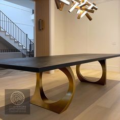 a modern dining table in the middle of a room with stairs and chandelier