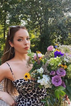 a beautiful young woman holding a bouquet of flowers