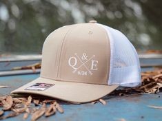 a truck cap with the word q e and crossed arrows on it sitting on top of leaves