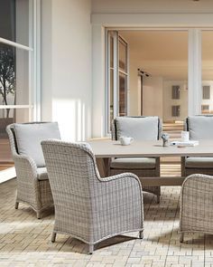 an outdoor dining table and chairs with white cushions