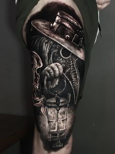 a man's leg with a black and white tattoo on it, featuring an image of a person holding a lantern