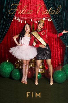 two people standing in front of christmas decorations