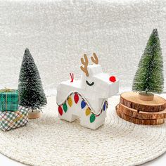 an origami christmas decoration with trees and presents on a white tablecloth background