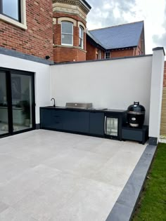 an outdoor kitchen on the side of a building