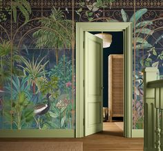 an open door leading to a green room with tropical wallpaper