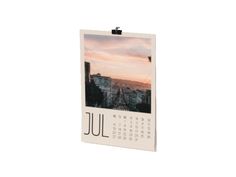 a calendar hanging on a wall with the city skyline in the background and an orange sky