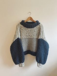 a knitted sweater hanging on a wooden hanger