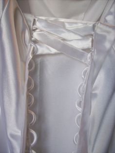 the back of a white dress with ruffles on it