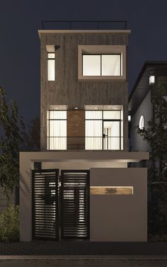 an exterior view of a modern house at night with lights on the windows and shutters open