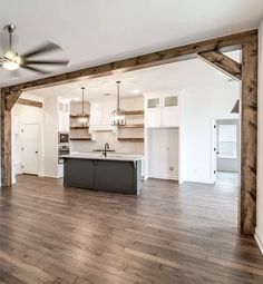 an empty kitchen and living room with wood floors