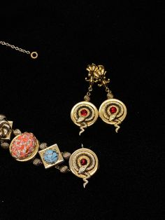 "Very little information can be found on the PIK MGK NYC jewelry makers but they did produce an exceptional art glass and serpent slide bracelet and earrings with this set; the dangle screw back earrings features the curled serpent and ruby red stone which matches one of the link on the bracelet and are 2\" long; the bracelet is 7\" long and 3/4\" wide with spring safety chain; each of the nine embossed links feature a different design and stone; the stone colors are amazing; ruby red, speckled Formal Metal Clip-on Jewelry, Art Deco Jewelry With Cabochon For Formal Events, Art Deco Cabochon Jewelry For Formal Occasions, Art Deco Cabochon Jewelry For Formal Events, Fine Jewelry Bracelet With Cabochon, Victorian Style Metal Clip-on Jewelry, Metal Clip-on Jewelry For Jewelry Making, Art Deco Clip-on Jewelry For Formal Occasions, Clip-on Art Deco Jewelry For Formal Occasions