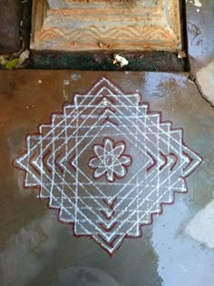 an intricate design on the ground in front of a door with chalk pasted onto it