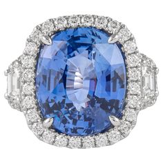 an oval blue and white sapphire ring with baguets on the sides, surrounded by diamonds