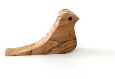 a wooden bird sitting on top of a white surface