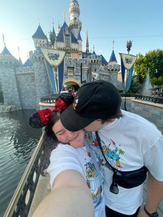 a man and woman taking a selfie in front of the castle at disney world