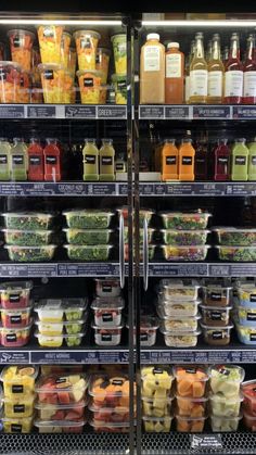 the refrigerator is stocked with many different types of juices and condiments in plastic containers