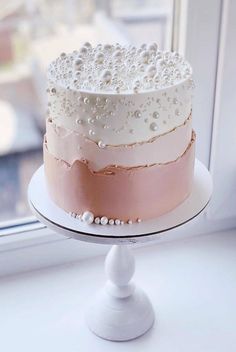 a three layer cake sitting on top of a window sill next to a window