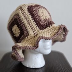 a crocheted hat sitting on top of a white mannequin head