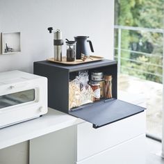 a microwave oven sitting on top of a counter next to a toaster and coffee pot