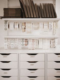 there are many stacks of papers on top of the drawers in this office space that is organized and organized