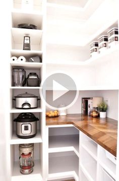 an organized pantry with white shelves and wooden counter tops