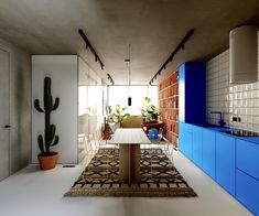 a dining room with blue cabinets and a rug on the floor in front of it