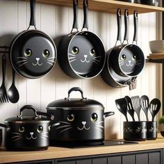 pots and pans with black cats painted on them are hanging from the wall in this kitchen