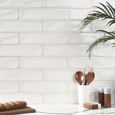 a kitchen counter with wooden utensils on it and a potted plant in the corner