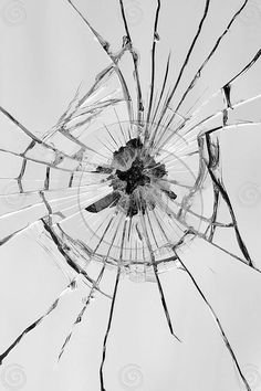 a broken glass window with the sky in the background