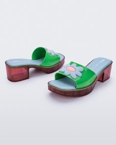 The favorite collab of recent times is making an exciting comeback. Melissa Shape + Lazy Oaf is full of nostalgia, inspired by the 90s and 2000s. The London brand is known for its bold colors, graphic designs, and subtle humor. The new clog-style model has the much-loved square toe alongside a low block heel. The daisies applied on the top are a joyful nod to the current trend. Retro Spring Platform Clogs, Y2k Shoes Clogs & Mules, Fun Green Non-slip Clogs, 90’s Platform Sandals, Green Flower-shaped Enamel Jewelry, Clog Style, London Brands, Clogs Style, Lazy Oaf