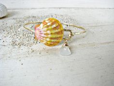 "The Sunrise Shell is prized for its rarity. It is found only in the Hawaiian Islands, and rarely found on the beach. Most of them are found by divers, deep in the ocean. My Sunrise Shells are found by my husband and a close family friend. Our Sunrise Shell creations are a true LABOR OF LOVE. From my husband diving to extreme depths to unearth these beauties beneath layers of sand, to the labor-intensive processing of the shell (to remove any natural calcification of the shell), to my final desi Beachy Shell Bracelet Jewelry, Coastal Style Bracelet Jewelry Gift, Ocean-inspired Gold Shell Bracelets, Beachy Shell Bracelet, Unique Beach Bangle Jewelry, Beachy Shell Bracelets As Gifts, Ocean-inspired Shell Bracelet Jewelry, Beachy Gold Shell Bracelets, Beachy Gold Bracelets With Shell