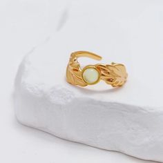 VINTAGE GOLD CALLA LILY CHALCEDONY RING Introducing our Vintage Gold Calla Lily Chalcedony Ring, a stunning piece that captures the essence of elegance and nature. This exquisite ring features a beautifully designed calla lily motif, symbolizing purity and beauty, elegantly embracing a luminous chalcedony stone at its center. Crafted in warm gold, the ring offers a luxurious yet delicate aesthetic, making it perfect for any occasion. Its adjustable design ensures a comfortable fit, allowing you to wear it effortlessly throughout the day. Whether as a statement piece or a cherished gift, this ring is a timeless addition to any jewelry collection, celebrating both artistry and the beauty of nature.   OTHER INFORMATION * The matching necklace, bracelet and earrings are available. * Materials: J Jewellery, Delicate Aesthetic, Chalcedony Stone, Chalcedony Ring, Velvet Bag, Calla Lily, Matching Necklaces, Ring Vintage, Women Accessories Jewelry