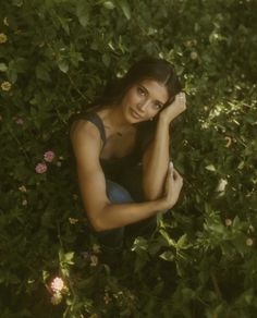 a beautiful young woman sitting in the grass