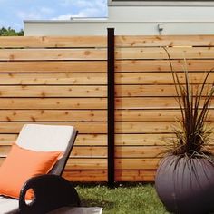 an orange and white chair sitting next to a wooden fence