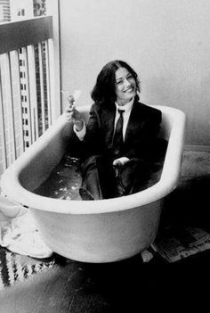 a man in a suit and tie sitting in a bathtub