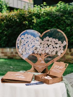 a table topped with a heart shaped tree cut out of wood and cards on top of it