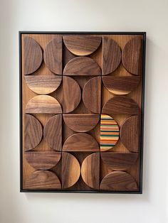 a wooden wall hanging on the side of a white wall